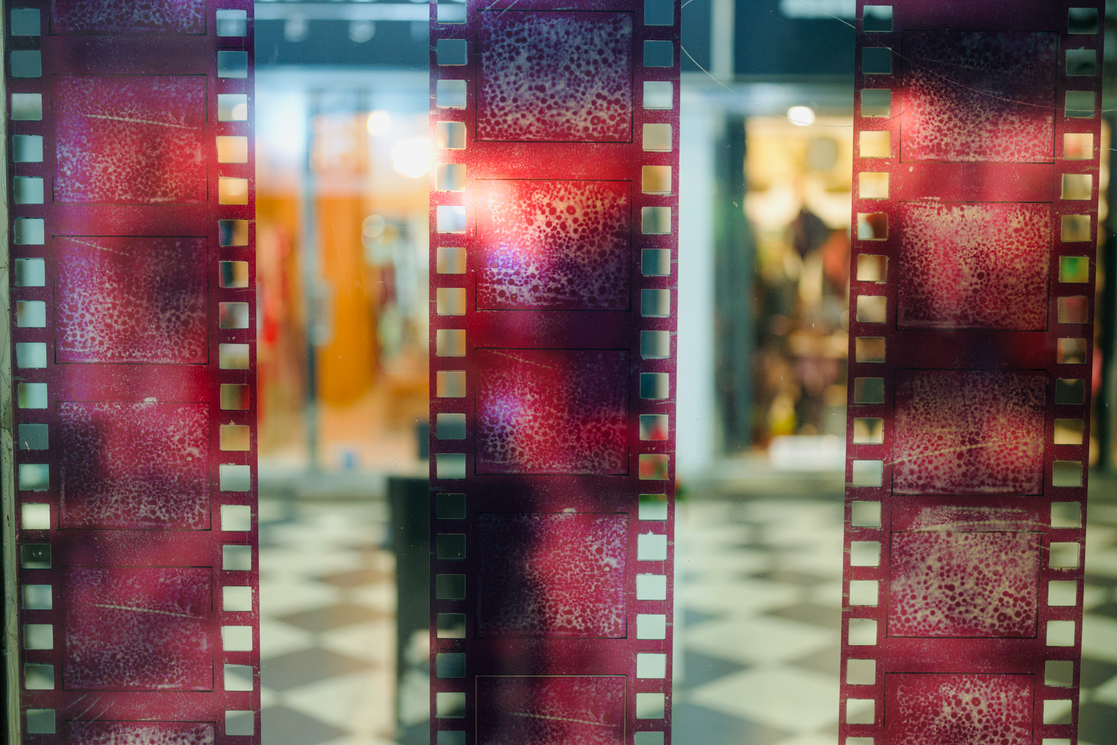Detalj instalacije filmske vrpce na staklu galerije.